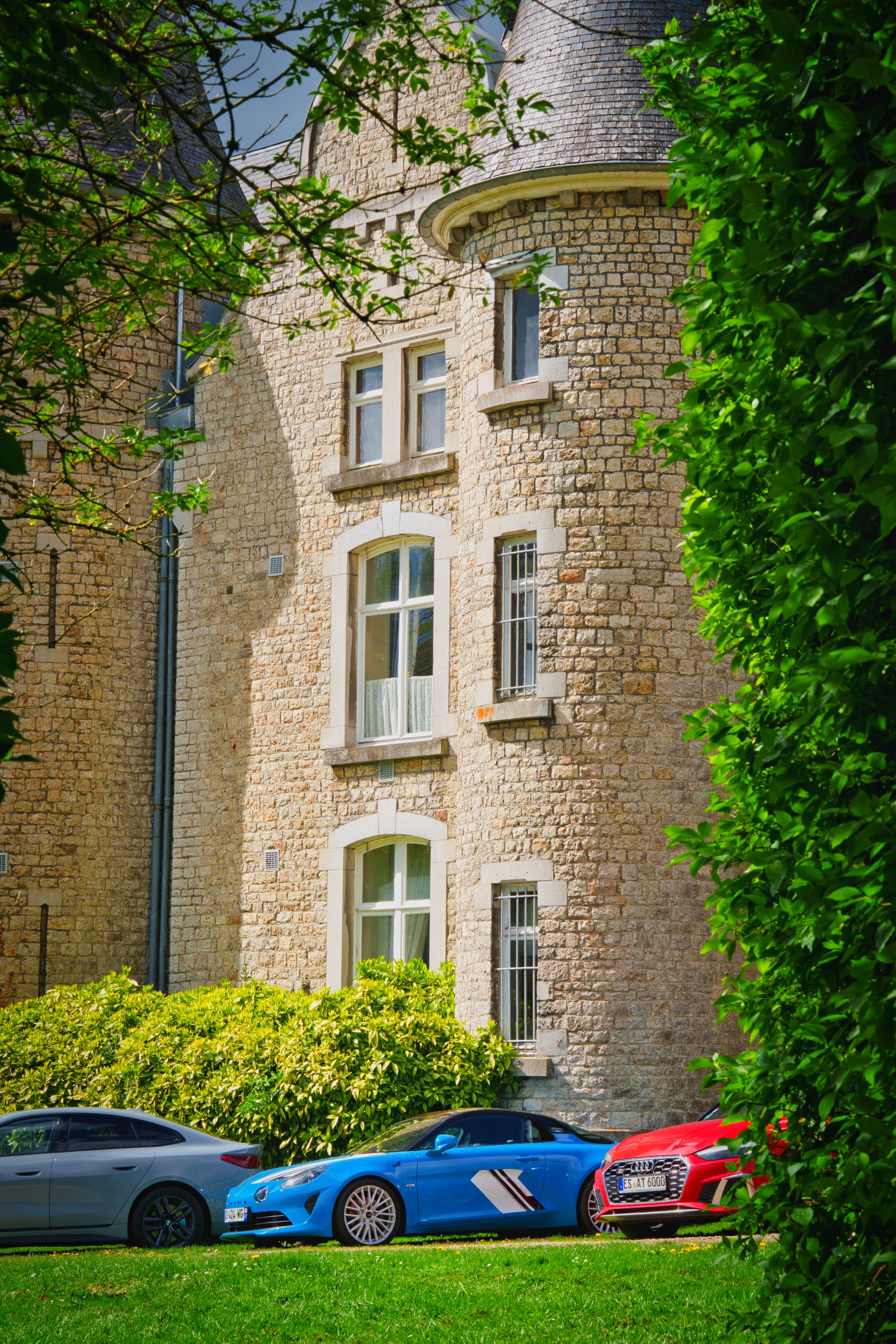 Tourelle en pierre d'un château vue à travers les arbres