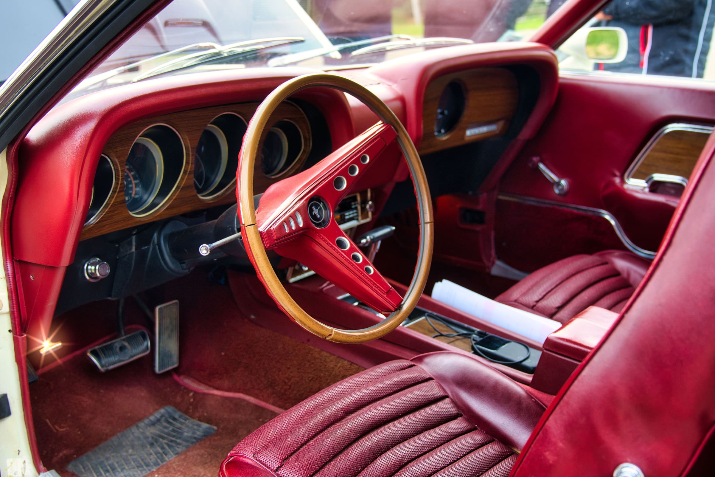 Intérieur rétro d'une Ford Mustang, volant en bois et sellerie rouge